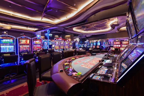 Vòng roulette phát sáng với chip đổ xuống, tượng trưng cho các trò chơi live và instant win trên MOBIMEG.