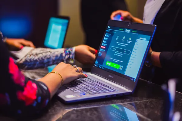 Một dealer tự tin giữa các chip casino mời người chơi truy cập tài khoản MOBIMEG, thể hiện quy trình đăng nhập nhanh chóng.